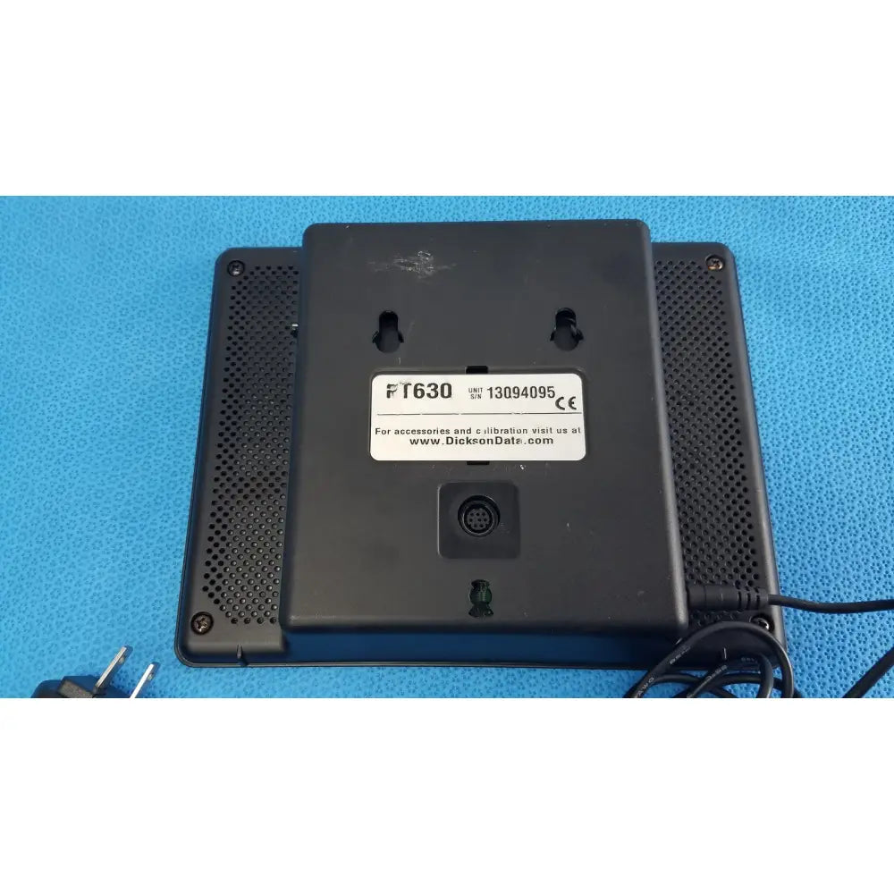 Black plastic dickson data logger ft630 device back panel with perforations and label showing model serial and ce mark
