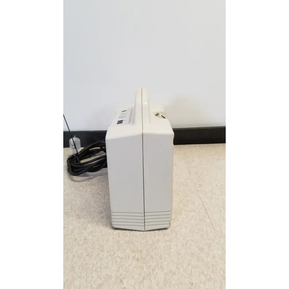 Cream-colored rectangular portable djo aircast venaflow 30a vascular system with handle and horizontal ridges