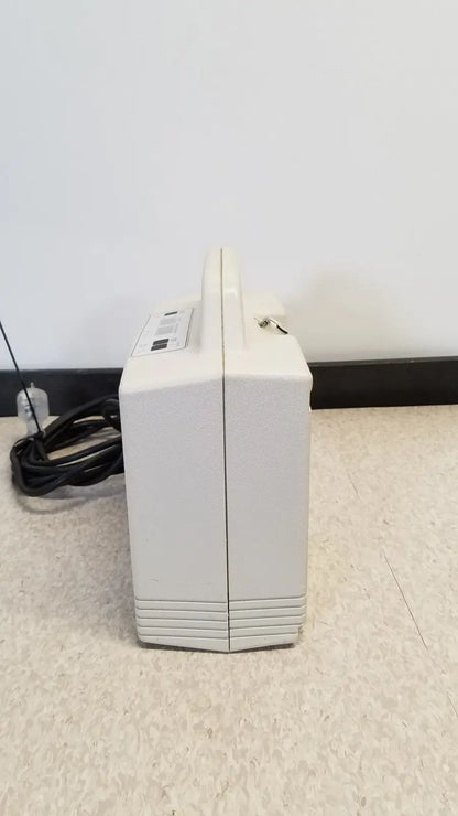 Cream-colored rectangular portable djo aircast venaflow 30a vascular system with handle and horizontal ridges