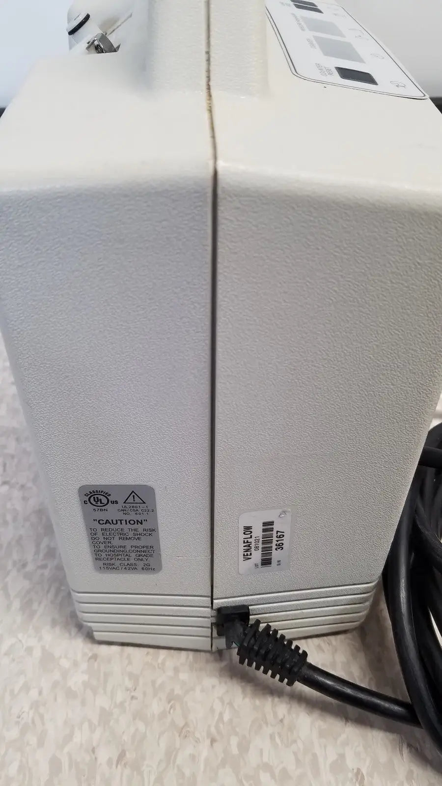 White plastic power supply unit with black cord and caution label for djo aircast venaflow 30a vascular system