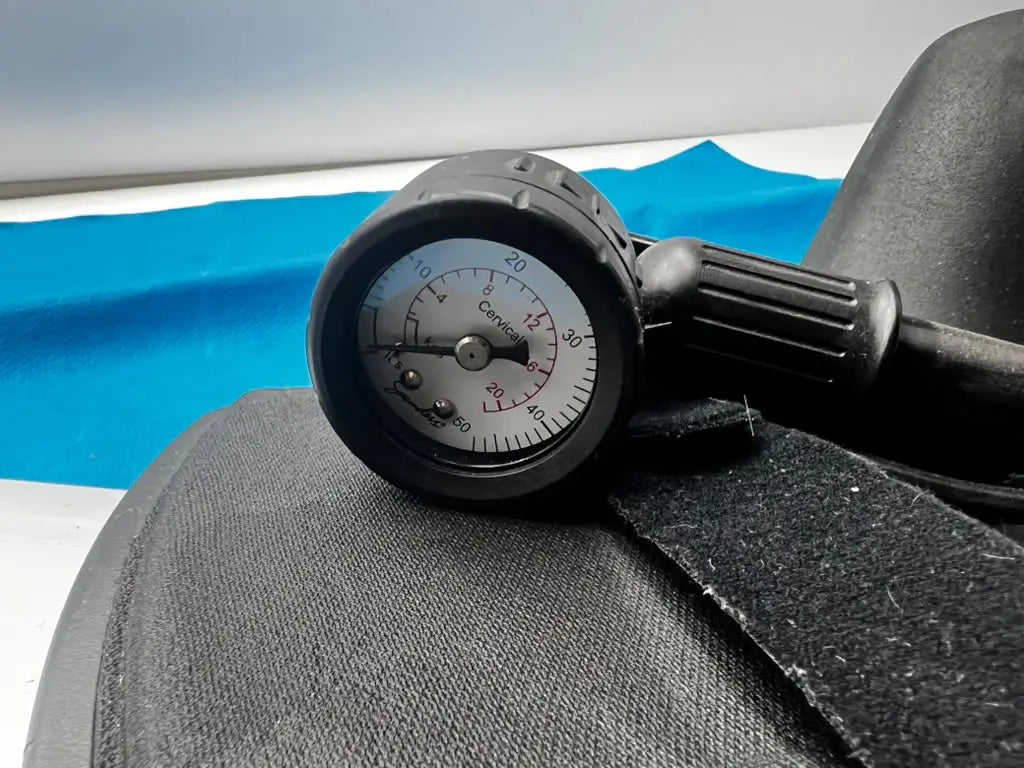 Black rubber pressure gauge with white dial and black needle marked cervical for djO global saunders cervical home traction device