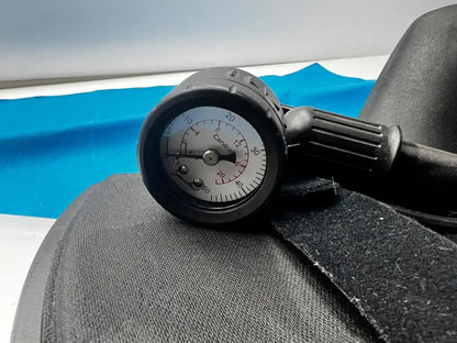 Black rubber pressure gauge with white dial and black needle marked cervical for djO global saunders cervical home traction device