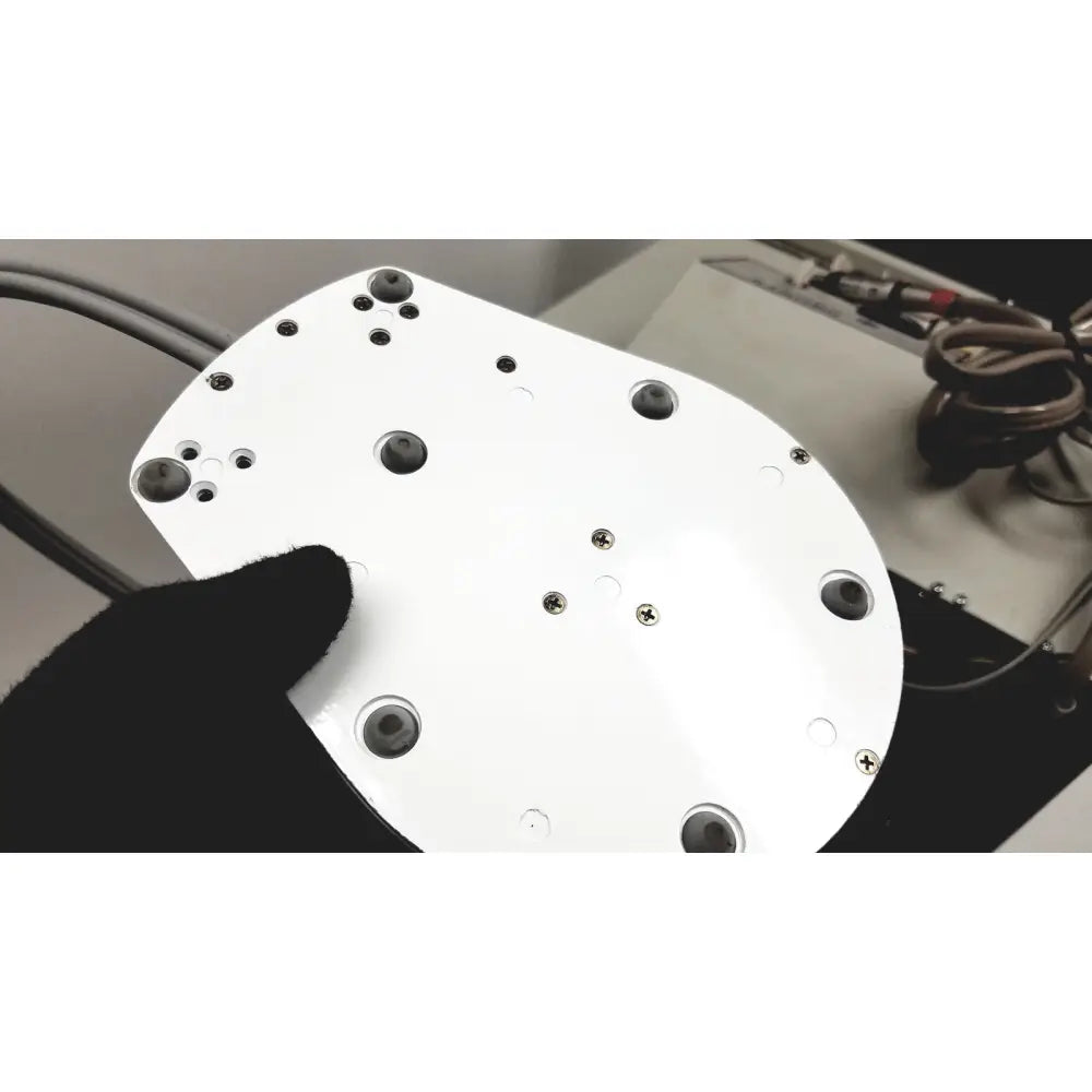 White circular plate with black rubber grommets and silver screws on dntl works p-2000 dental delivery unit back side