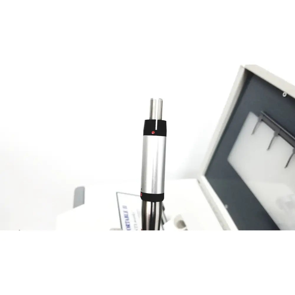 Silver and black cylindrical dntl works p-2000 dental delivery unit with red dot on upper black band for dental use