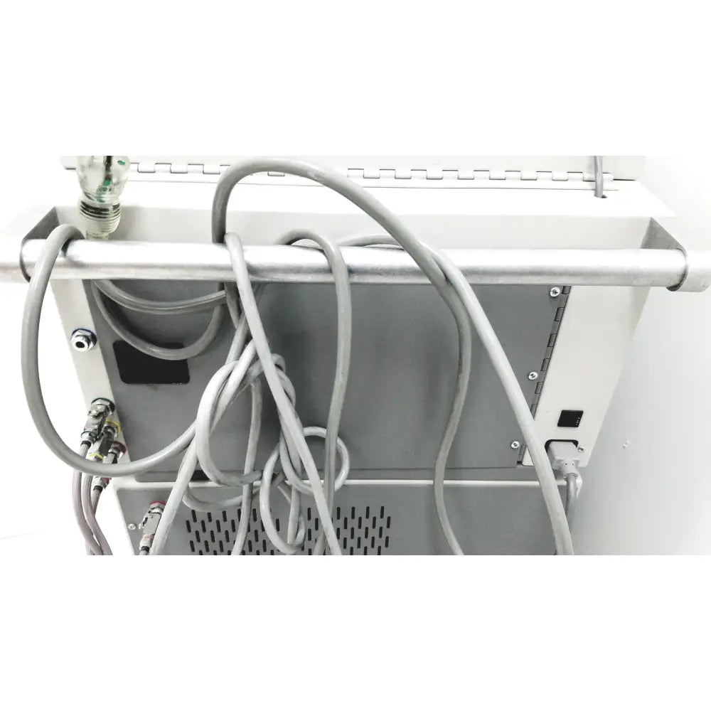 Gray coiled cables hang from the metallic bar at the back of the white dntl works p-2000 dental delivery unit with midwest rhino