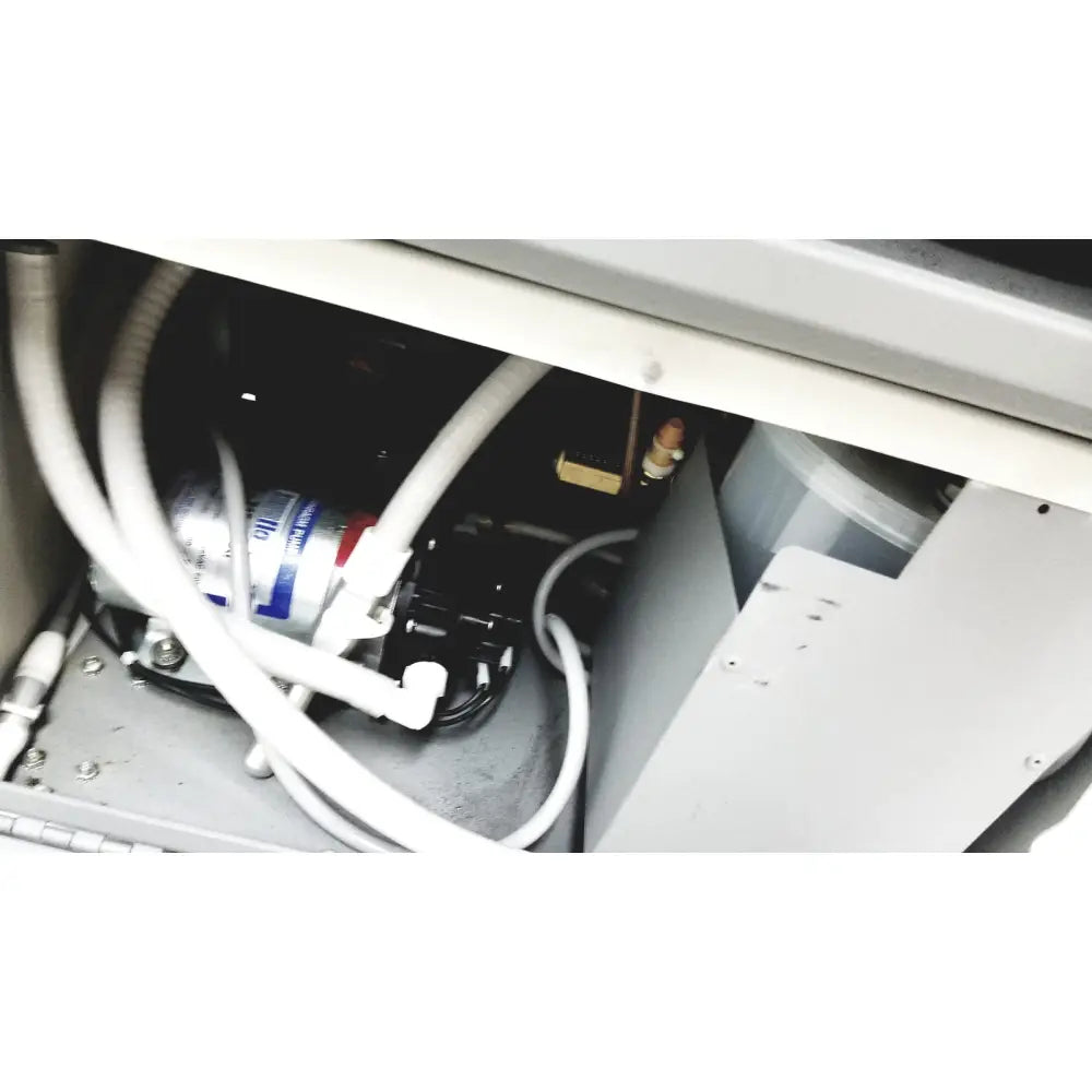 Silver cylindrical water filter with blue and white labeling mounted inside cabinet on dntl works p-2000 dental delivery unit