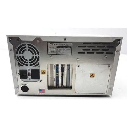 Back panel of dynatech mrx microplate reader showing blue db-9 serial and auxiliary ports on metallic housing