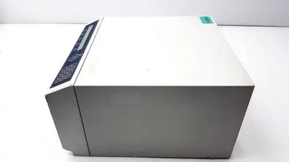 Gray rectangular dynatech mrx microplate reader with black control panel and green label for laboratory use