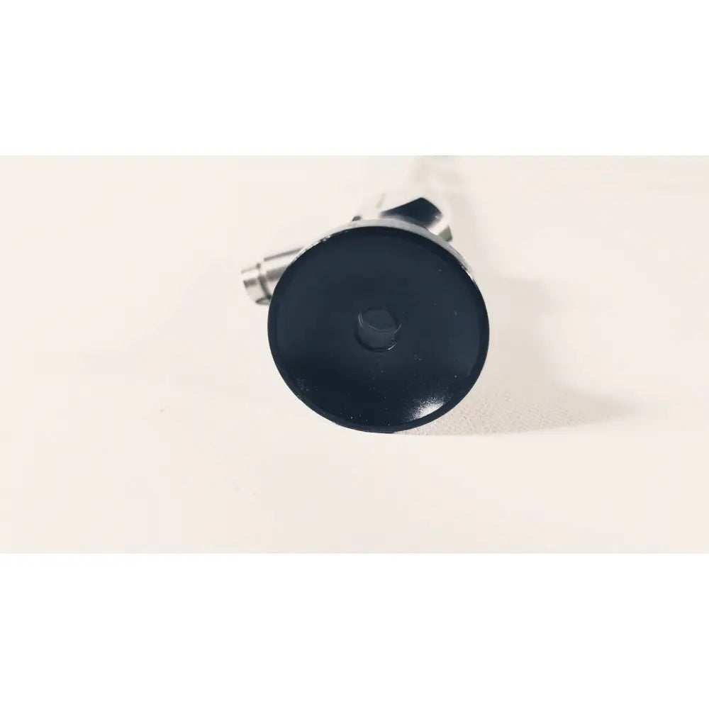 Black circular cap with central hexagonal bolt attached to metallic parts of dyonics autoclave degree 10mm laparoscope