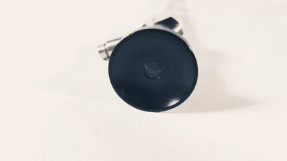 Black circular cap with central hexagonal bolt attached to metallic parts of dyonics autoclave degree 10mm laparoscope