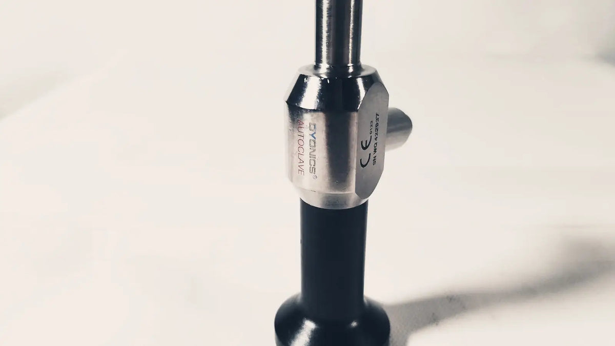 Silver-toned metallic hexagonal collar with engraved branding on black handle of dyonics autoclave degree 10mm laparoscope