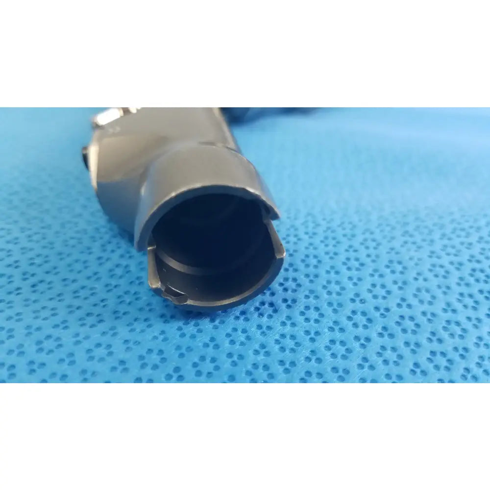 Gray metallic cylindrical powermax elite shaver handpiece connector with hollow interior and visible mechanical fittings for medical equipment