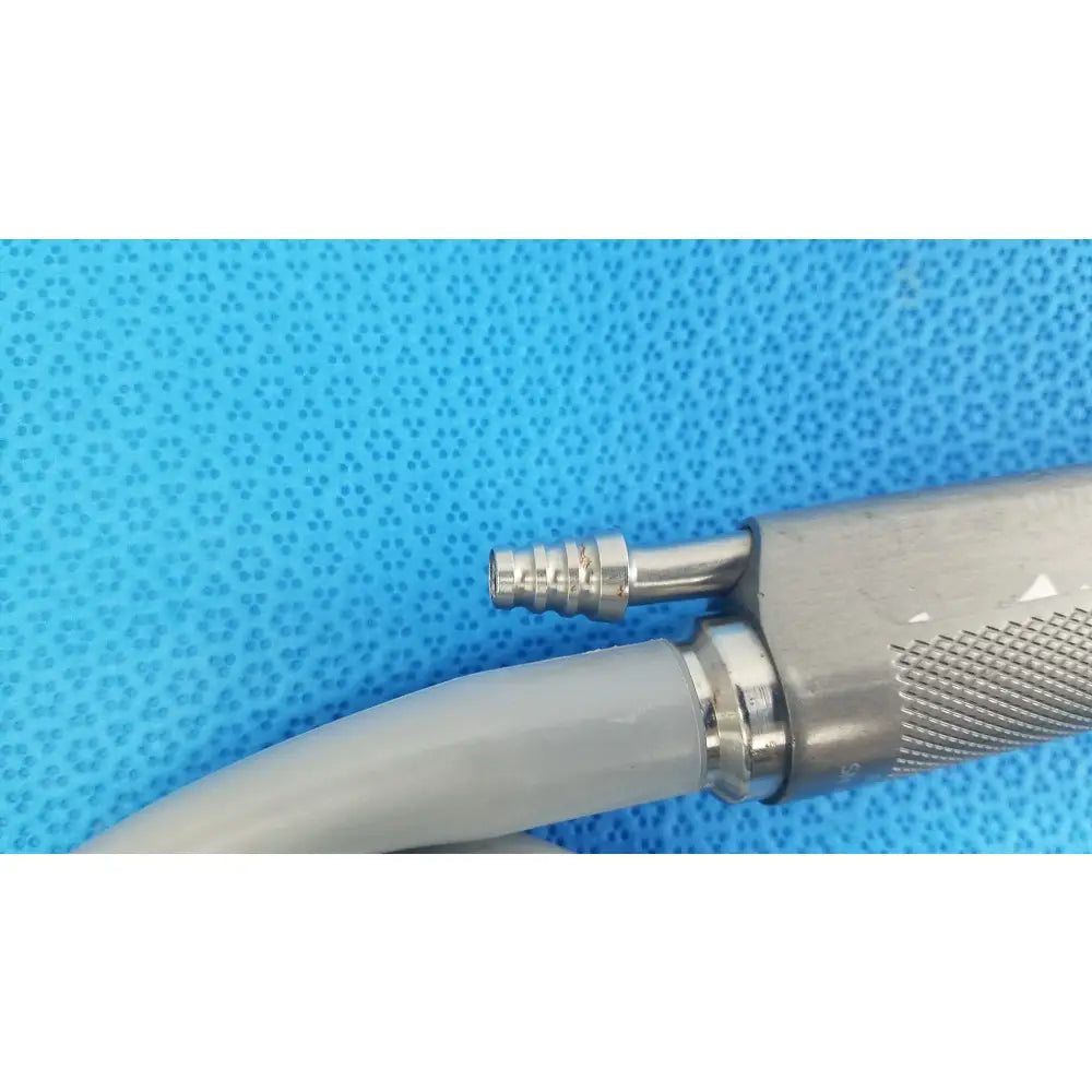 Silver metallic dyonics powermax elite shaver handpiece with textured grip and threaded connector for medical equipment use