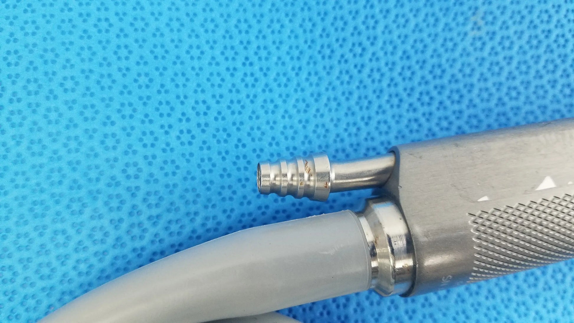 Silver metallic dyonics powermax elite shaver handpiece with textured grip and threaded connector for medical equipment use