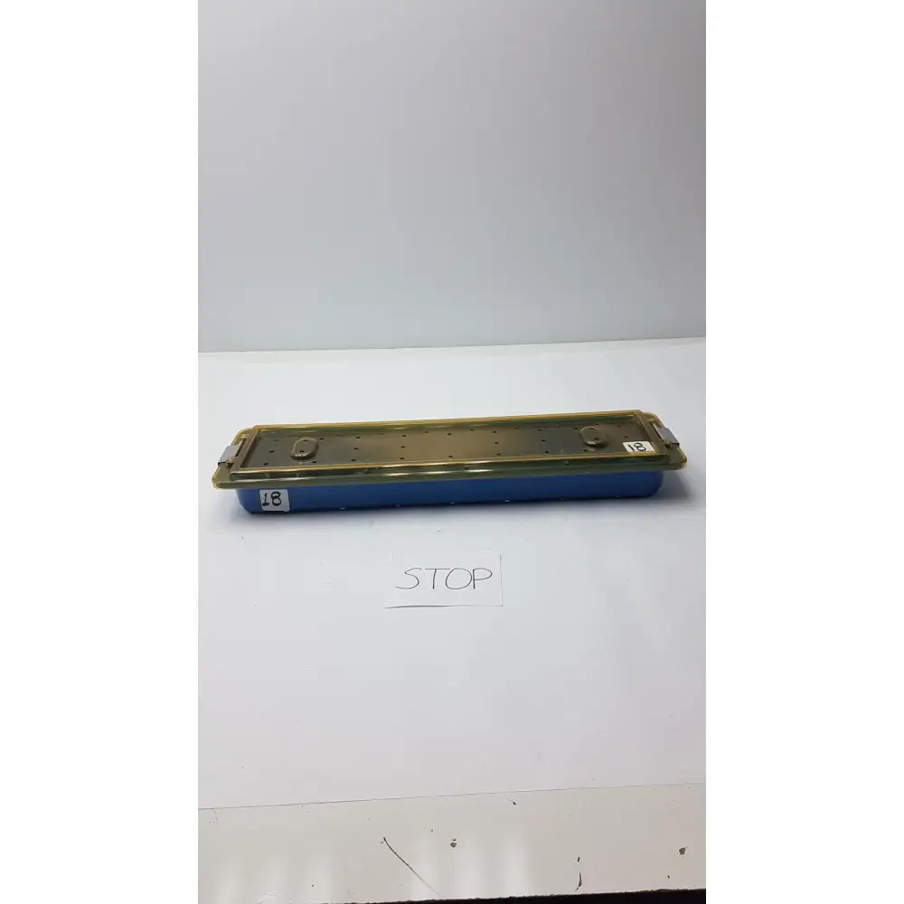 Blue plastic dyonics video sterilization soaking tray case with gold metal lid, latches, and instrument organizing holes