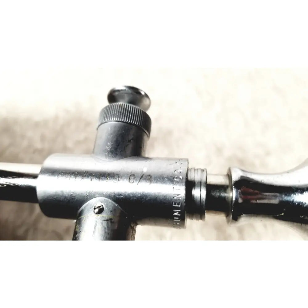 Silver-colored metal eder instrument cat surgical instrument with engraved markings and textured knob for endoscope use
