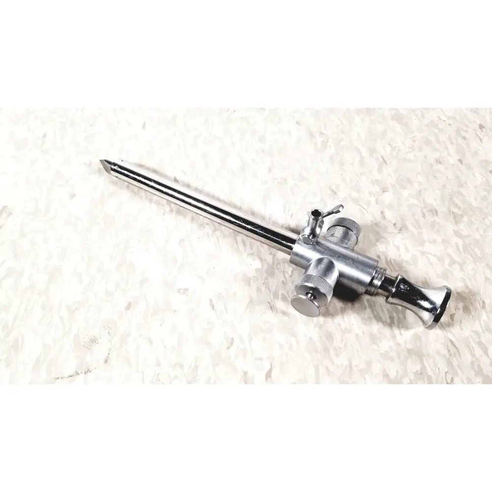 Silver-colored metal eder instrument cat surgical endoscope with long slender shaft and multiple adjustment knobs
