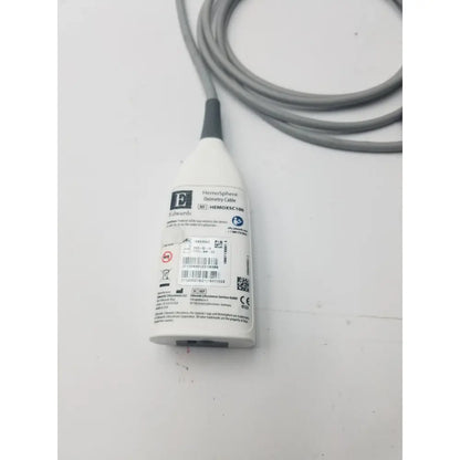 White plastic edwards hemosphere oximetry cable with gray coiled cord and black connector for medical use