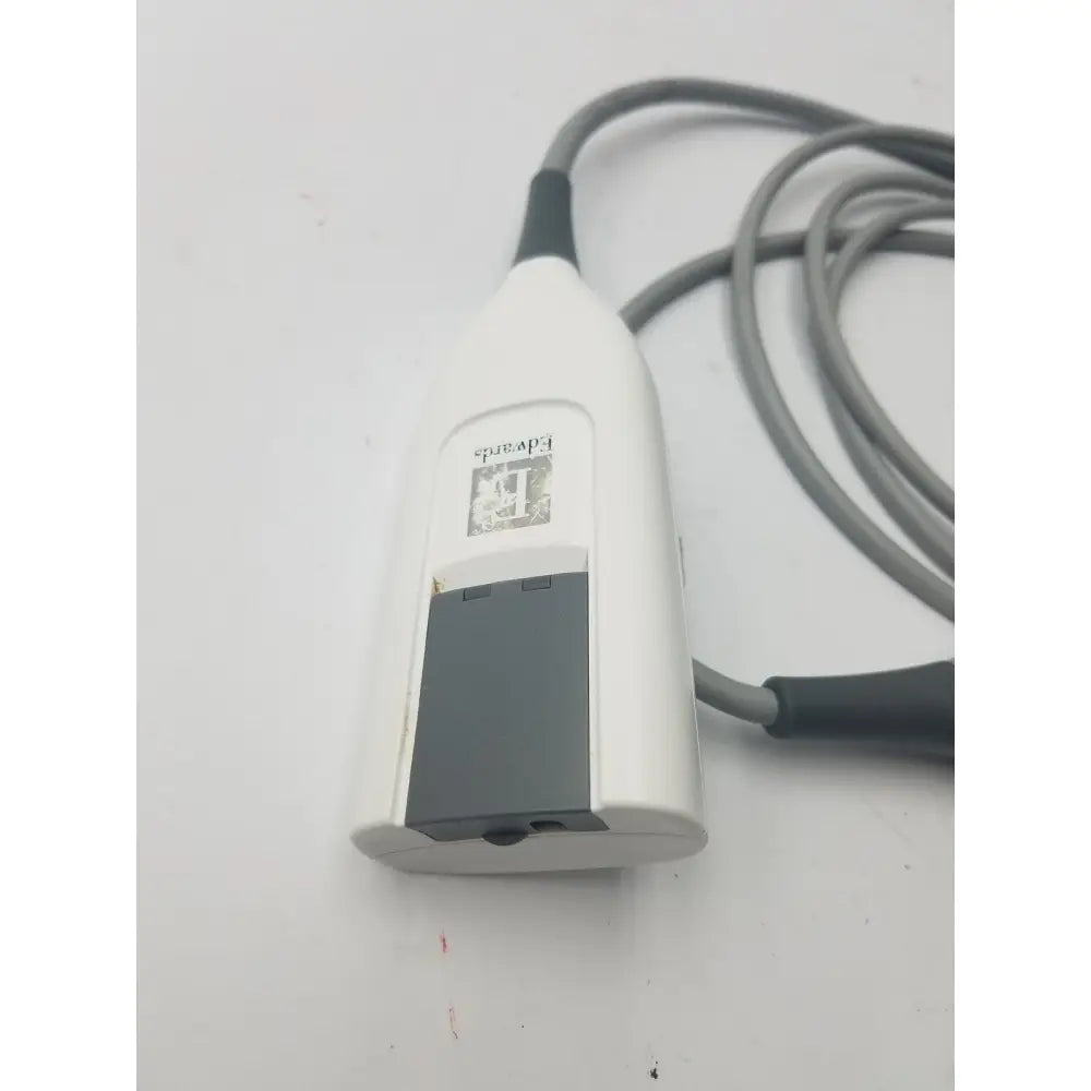 White handheld edwards hemosphere oximetry cable with gray cord and small screen for accurate pulse monitoring