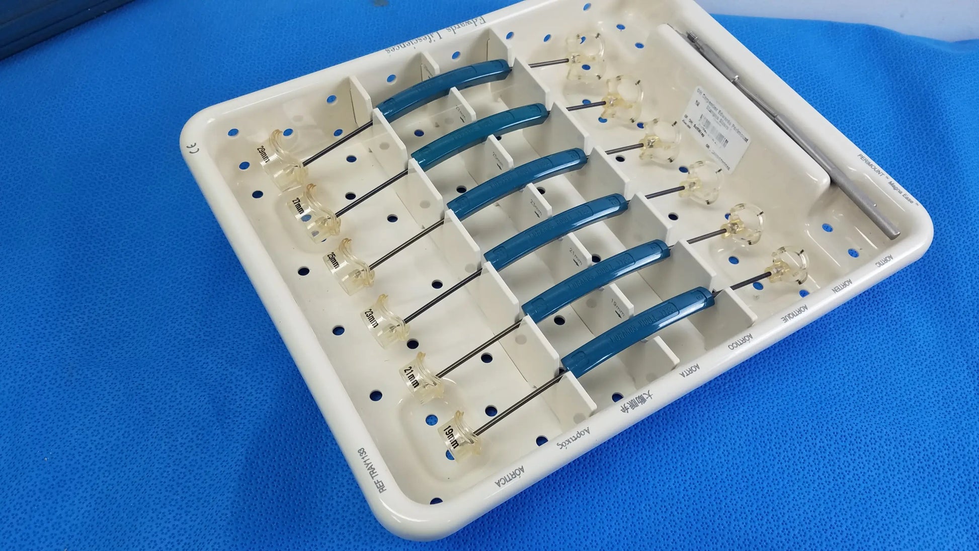 White plastic surgical tray holding six blue-handled dental instruments with glass tips for buy used medical equipment