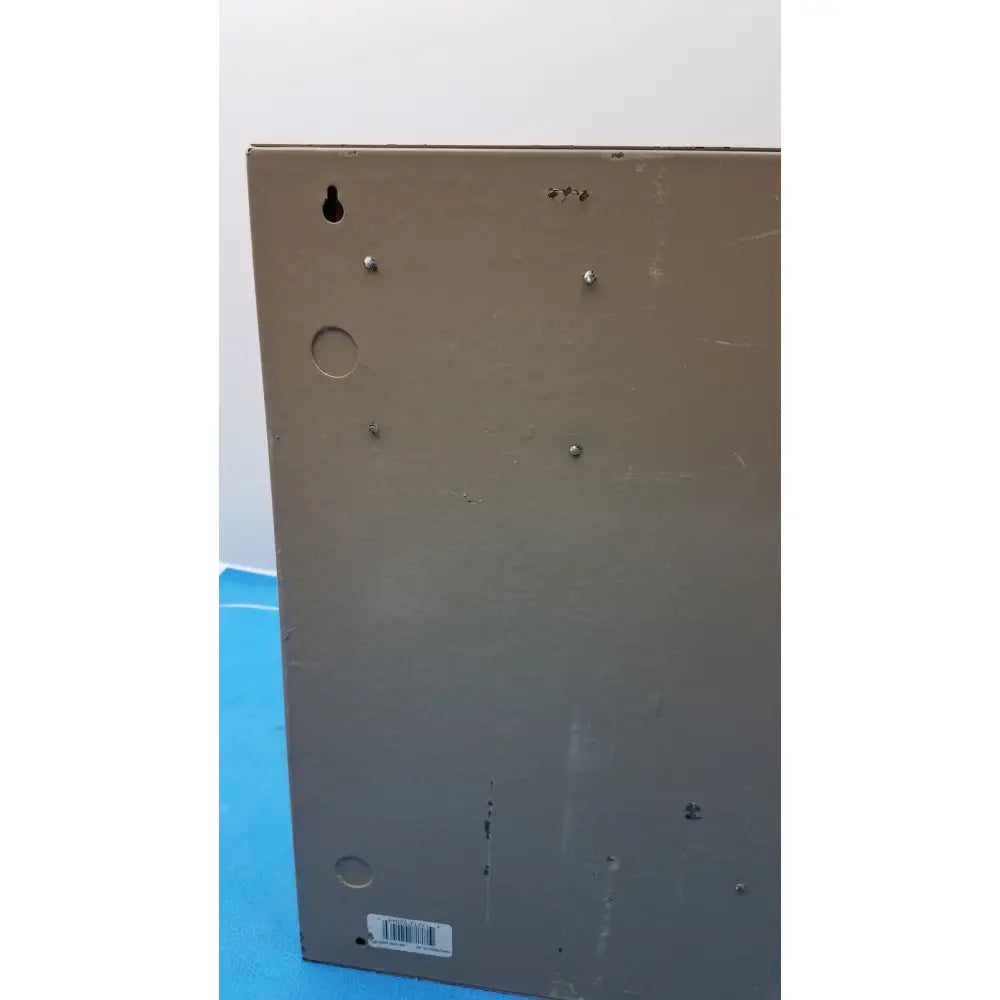 The back of a beige metal-framed electrical control panel featuring mounting holes for time delay relay installation