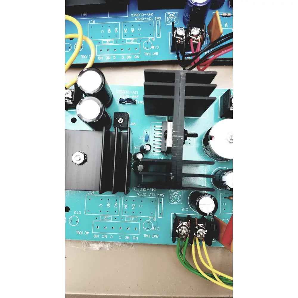 Blue electrical control panel circuit board with black capacitors heat sinks and yellow green wires featuring time delay relay