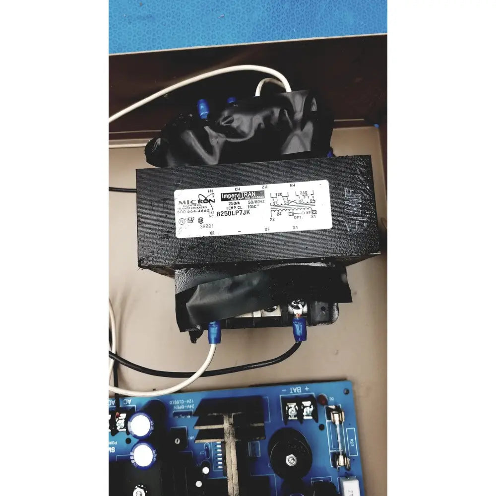 Black micron transformer with white label and blue terminals in electrical control panel with time delay relay