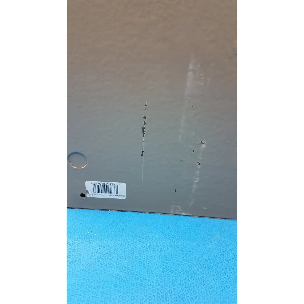 Gray plastic box bottom of electrical control panel with white barcode label and minor scratches showing timer relay use