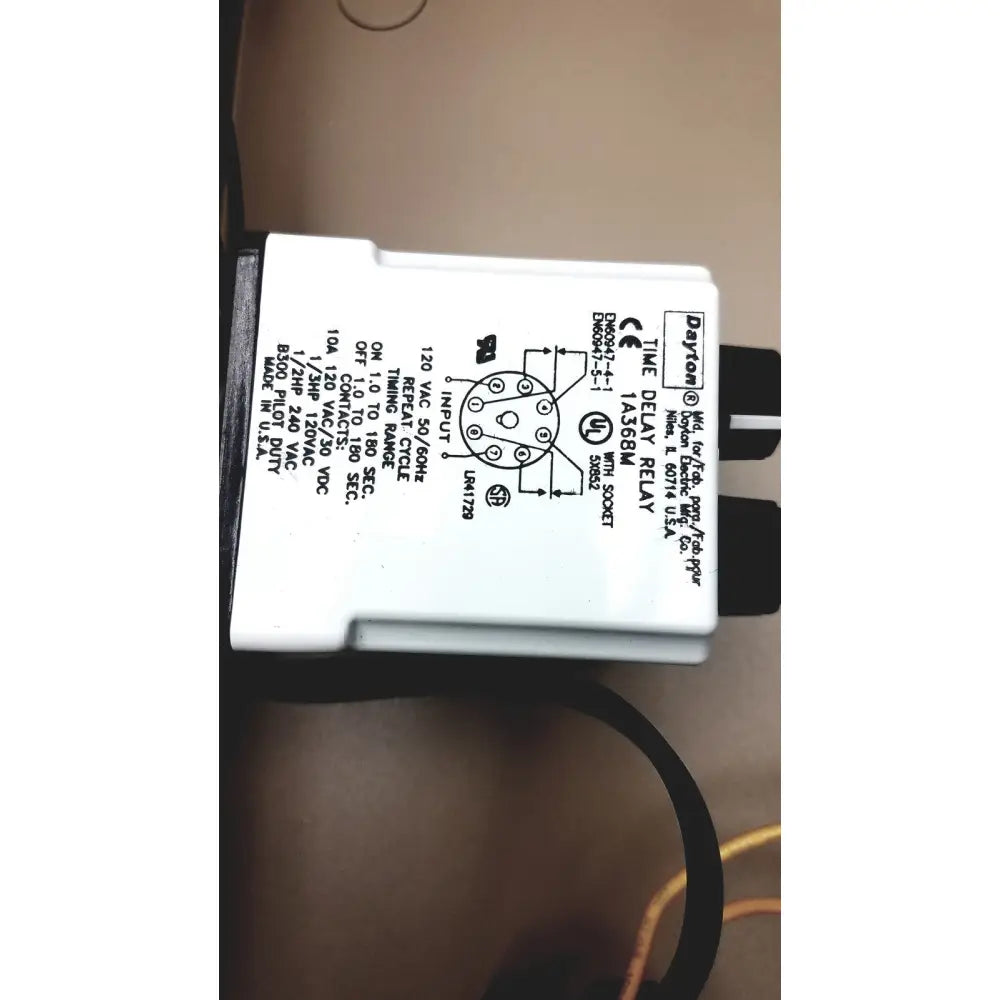 White plastic time delay relay with black wiring and printed specifications in electrical control panel for time delay relay