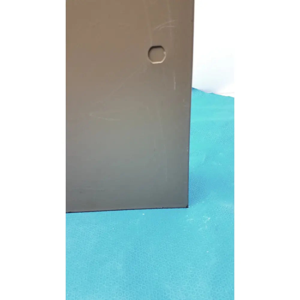 Gray rectangular metal plate with hexagonal hole for electrical control panel with time delay relay and transformers