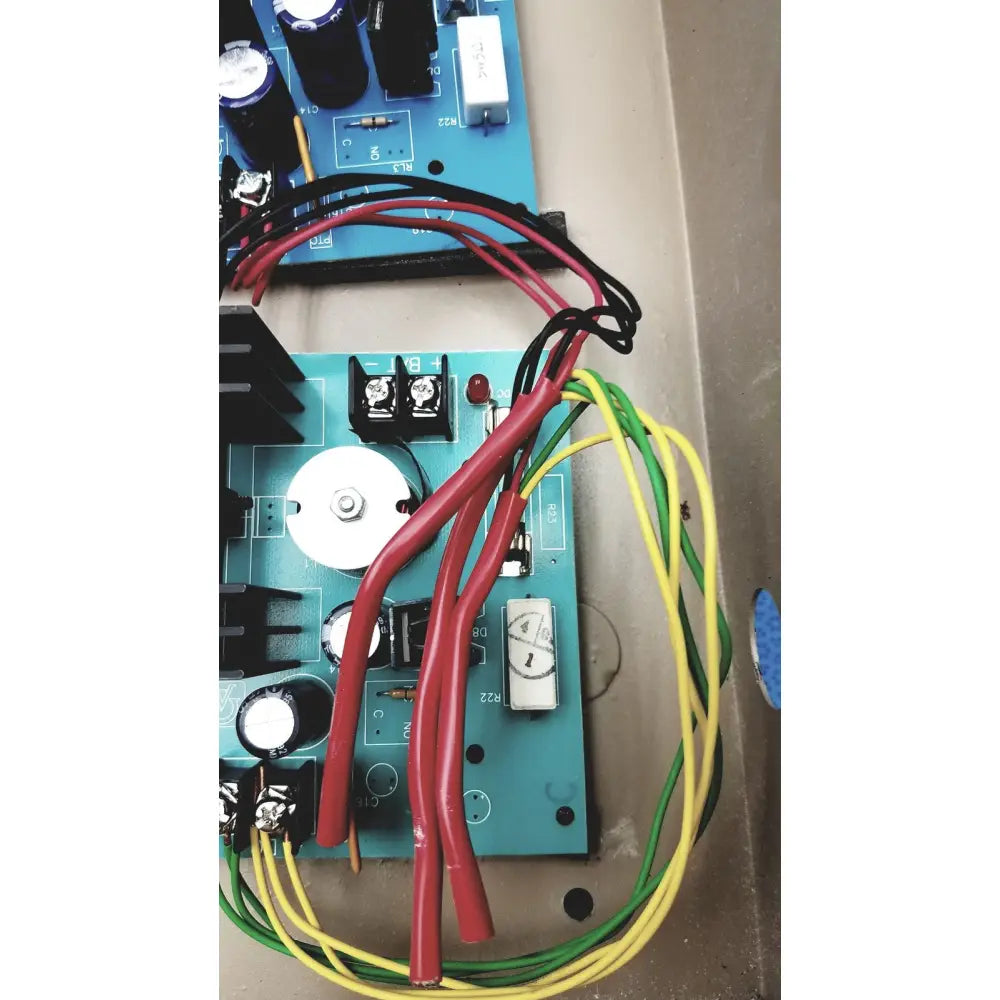 Blue circuit board electrical control panel with time delay relay and transformers connected by red black and yellow wires