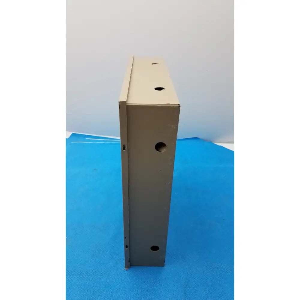 Beige metal electrical control panel enclosure with evenly spaced circular holes featuring time delay relay and transformers