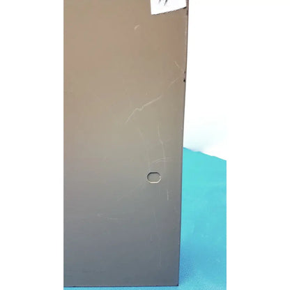 Matte gray metal electrical control panel with time delay relay featuring a small oval hole and faint surface scratches