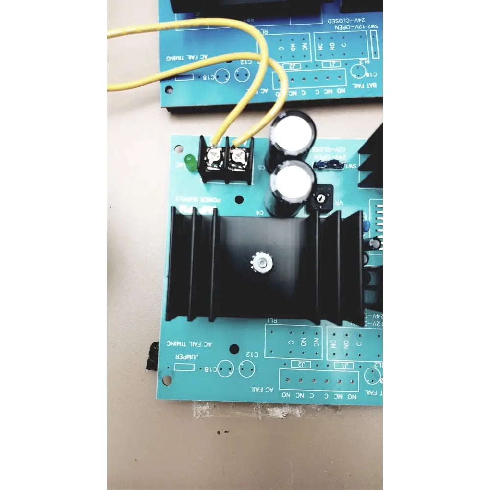Teal electrical control panel circuit board with black heat sink and capacitors featuring time delay relay and transformers