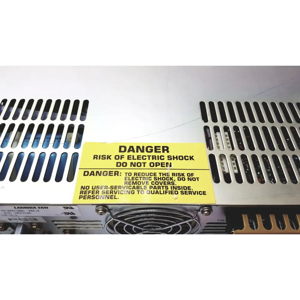 Yellow warning label on the back of electronic measurements ems power supply cautioning against electric shock risk