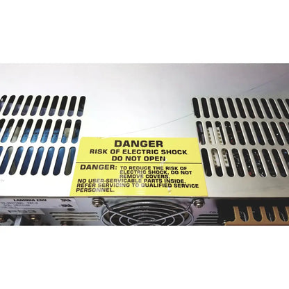 Yellow warning label on the back of electronic measurements ems power supply cautioning against electric shock risk