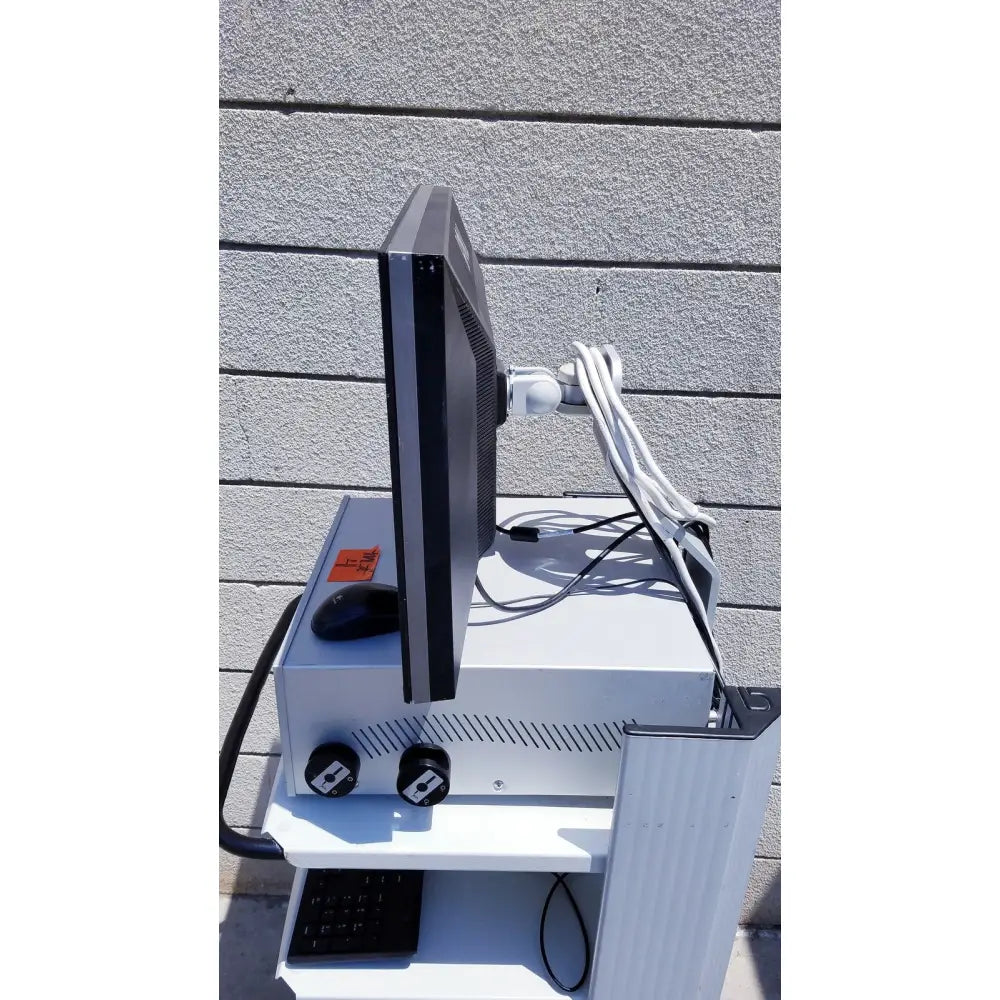 Black ellex eyecubed ultrasound biomicroscopy system monitor mounted on white cart with keyboard and two black knobs