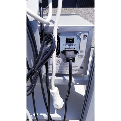 Black electrical plug connected to white power cord on the back panel of gray ellex eyecubed ultrasound biomicroscopy system