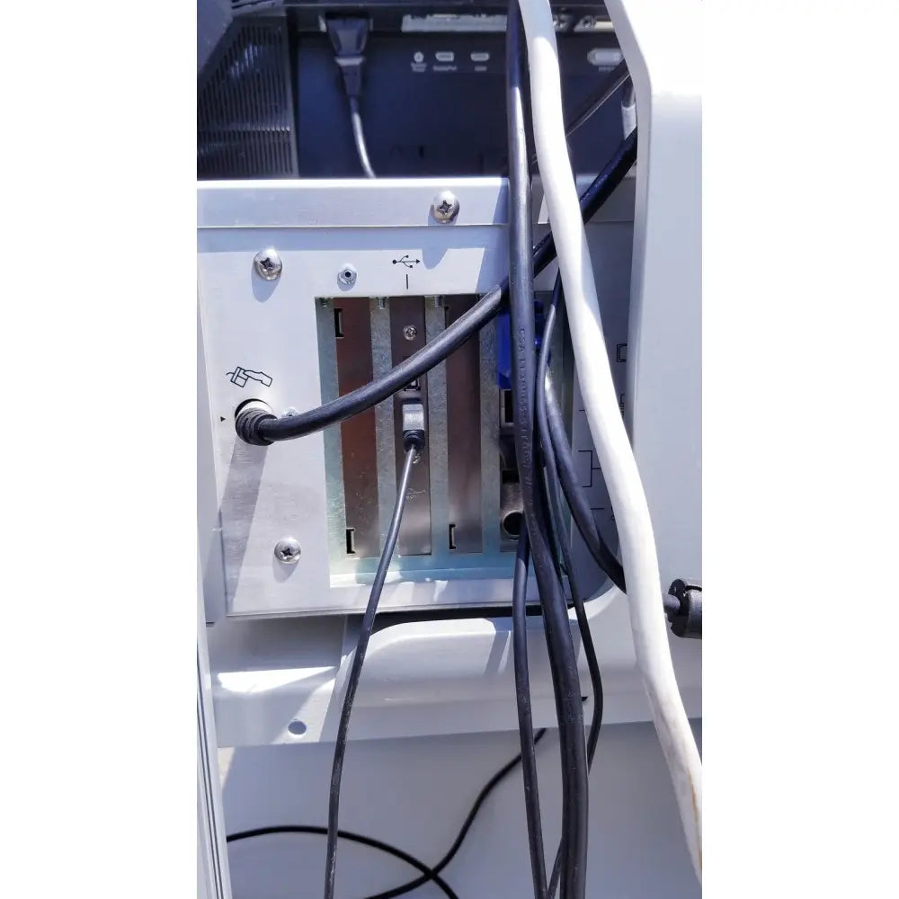 Back view of ellex eyecubed ultrasound biomicroscopy system white plastic panel with silver screws usb port and cable management