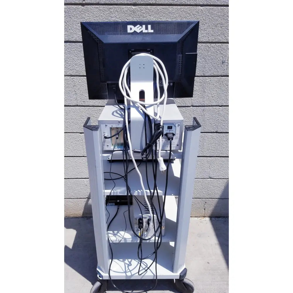Black dell monitor mounted on a white wheeled cart with cables showcasing ellex eyecubed ultrasound biomicroscopy system as-is