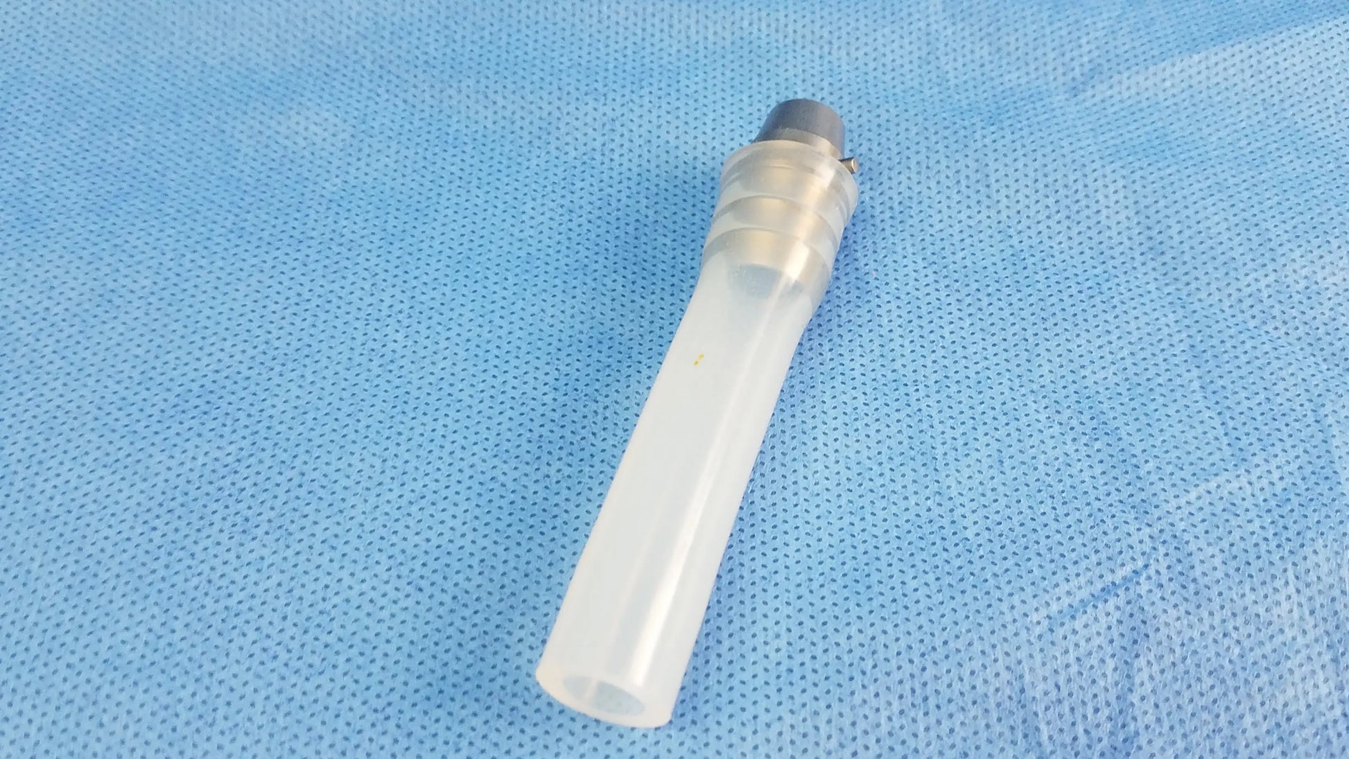 Transparent plastic ellik evacuator adapter with ridged tube and gray metallic cap compatible endoscopic systems