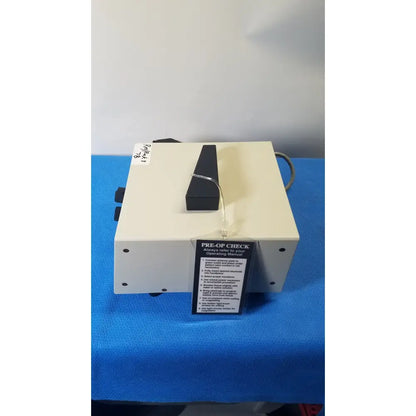 Cream-colored ellman surgitron emc electrosurgical unit with black handle cable and pre-of-check label for surgical use
