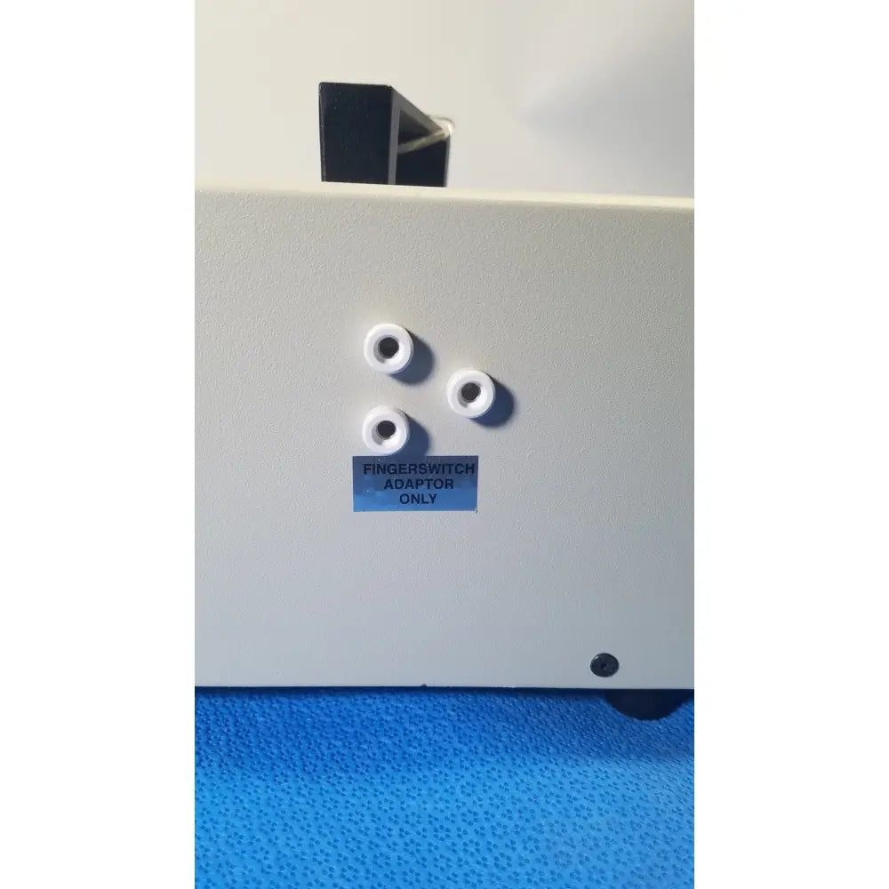 White plastic fingerswitch adaptor with four circular ports and blue label for ellman surgitron emc electrosurgical unit foot pedal