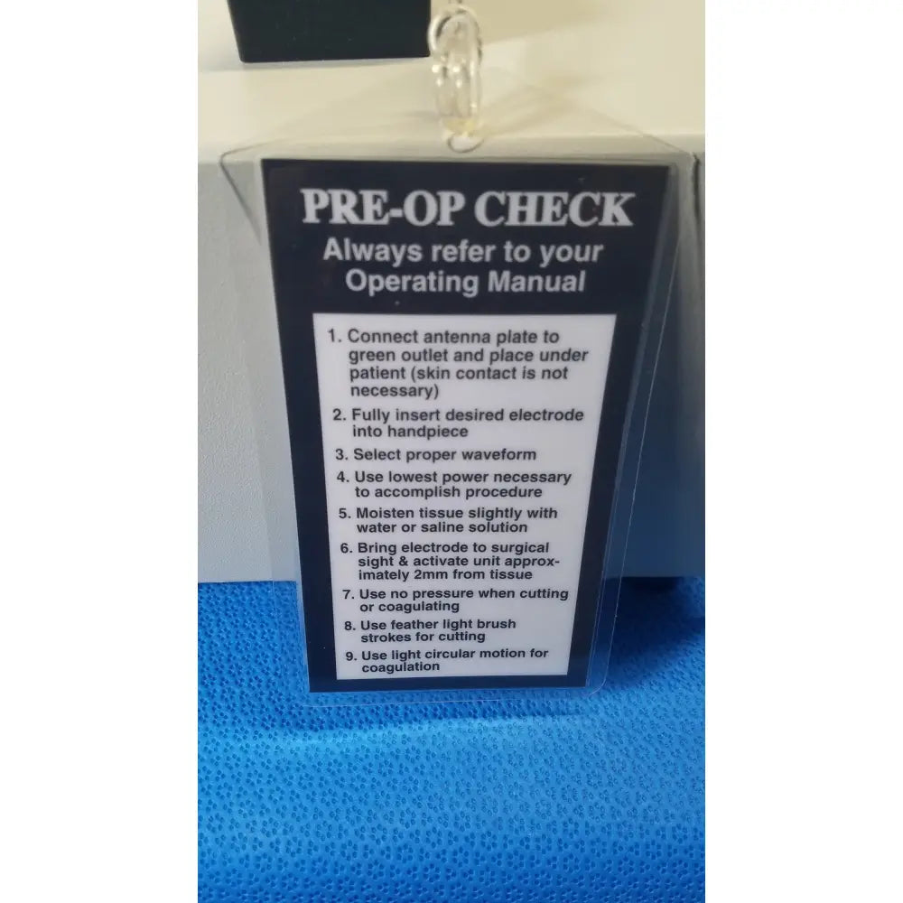 Pre-op check instruction label on the back of ellman surgitron f.f.p.f. emc electrosurgical unit with foot pedal