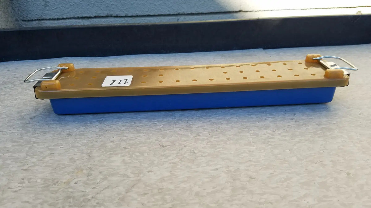 Blue and tan plastic sharpening stone with metal clamps for secure use in an endoscope sterilization case tray