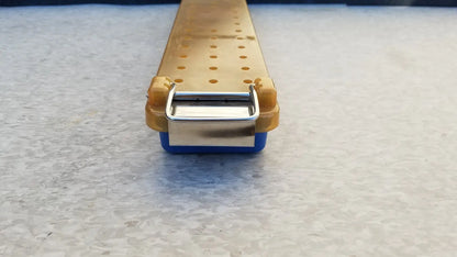 Yellow and blue plastic endoscope sterilization case tray with a metallic clasp for secure sterilization case use