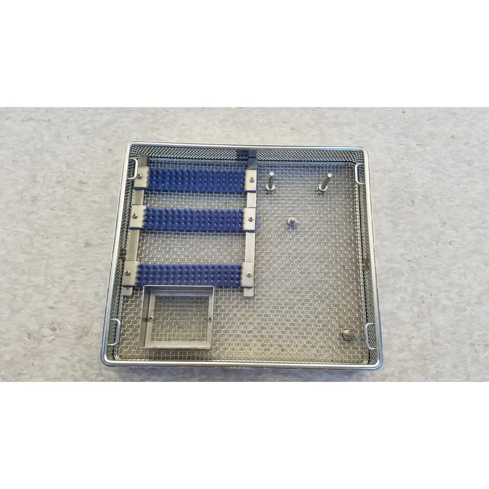 Entific sterilization case tray in stainless steel with three blue rubber grips and multiple metal pins for instruments