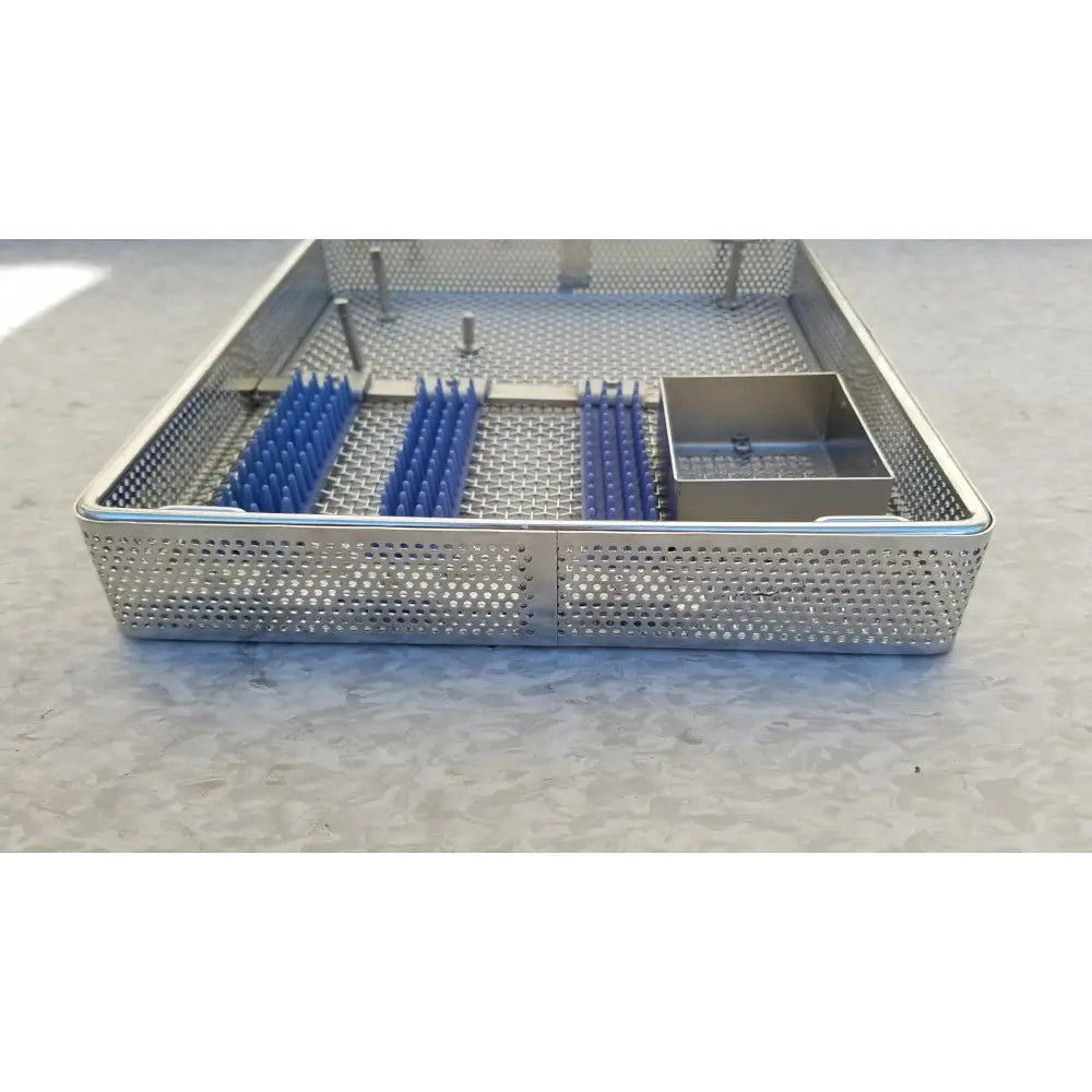 Stainless steel entific sterilization case tray with blue plastic inserts and a small metal compartment for instruments