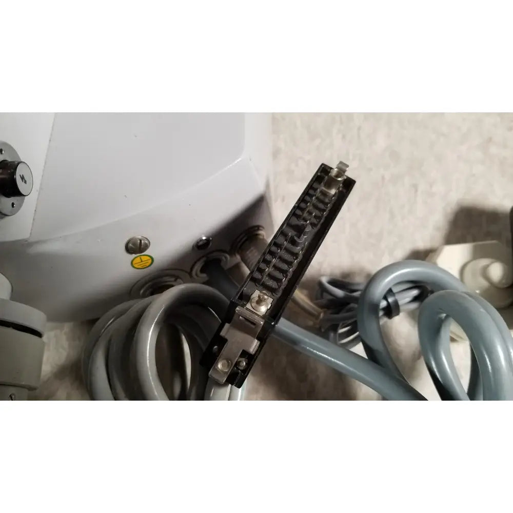 Black rectangular connector with metallic pins and silver screws attached to gray coiled tubing on eppendorf centrifuge 5415 r reuse medical component