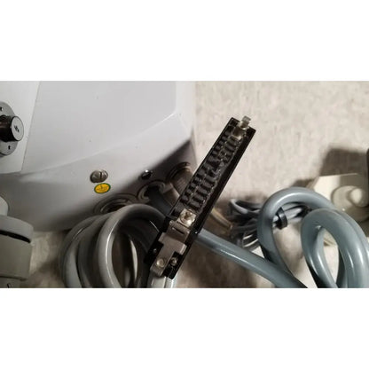 Black rectangular connector with metallic pins and silver screws attached to gray coiled tubing on eppendorf centrifuge 5415 r reuse medical component
